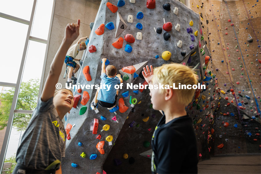 Campers discuss their strategy as others take on the climbing wall. Husker Kids Camp. July 25, 2023.  Photo by Craig Chandler / University Communication.