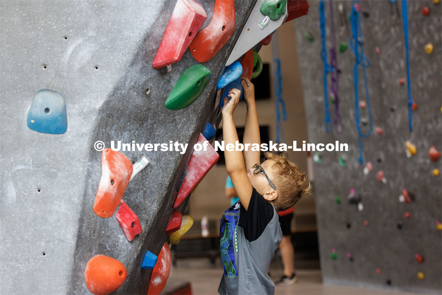 One camper climbs on the rock wall at the Outdoor Adventures Center. Husker Kids Camp. July 25, 2023.  Photo by Craig Chandler / University Communication.