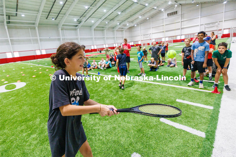 One camper tries to not let their tennis ball get away from them in the tennis relay. Campers had to bounce a ball on their racquet walking backwards and forwards. Husker Kids Camp. July 25, 2023.  Photo by Craig Chandler / University Communication.