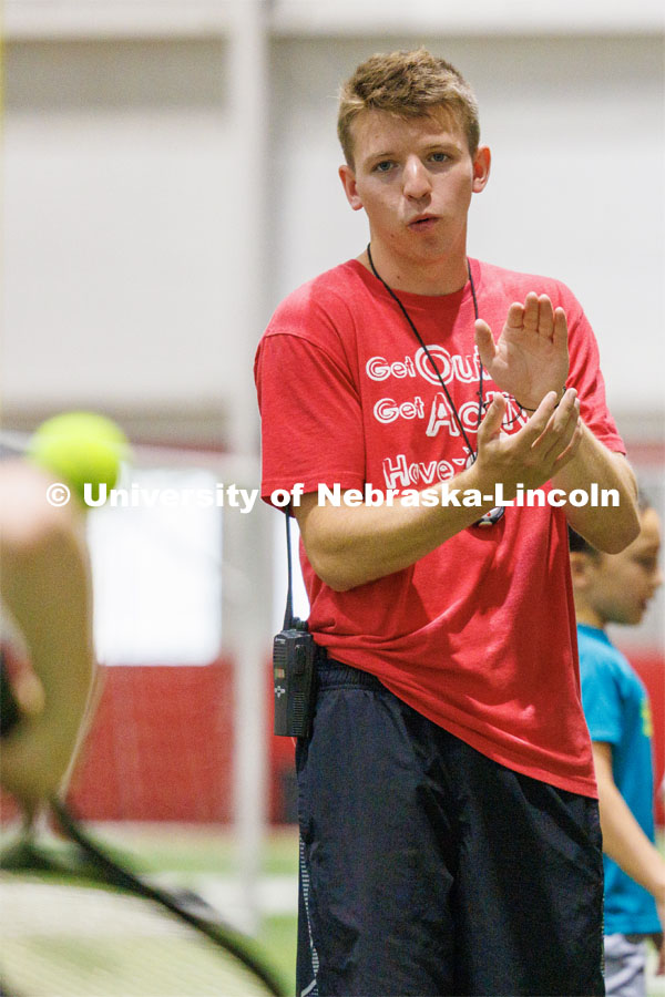 Carson Linquist, a senior from Omaha, encourages a camper in the tennis relay. Husker Kids Camp. July 25, 2023.  Photo by Craig Chandler / University Communication.
