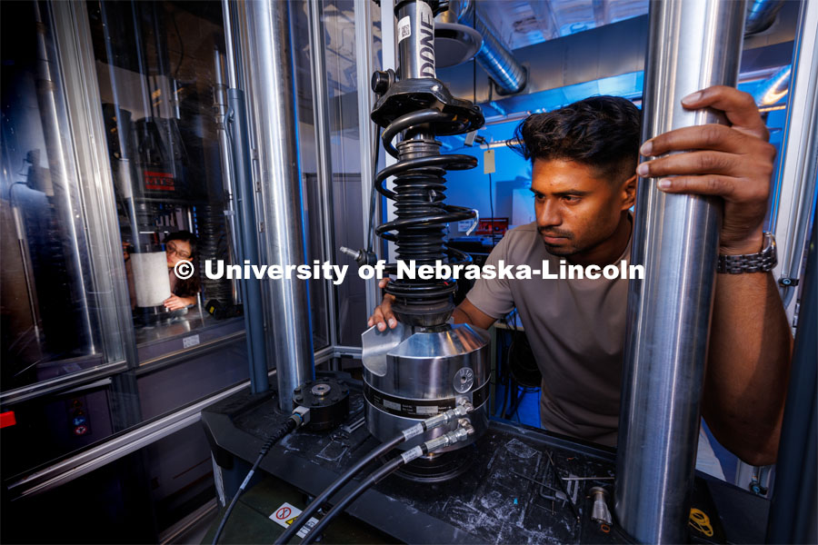 Gnyarienn Selva Kumar works on setting up a strut for a compression test while Doreen Rahman does the same for a concrete sample. Both are masters students in mechanical engineering. They work in Cody Stolle’s lab in Whittier. July 27, 2023. Photo by Craig Chandler / University Communication.