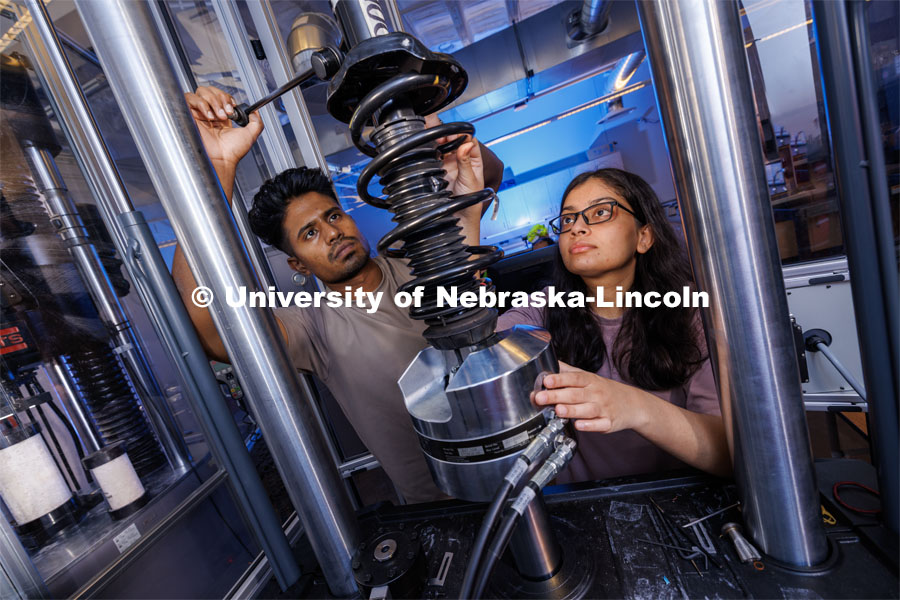Gnyarienn Selva Kumar, left, and Doreen Rahman work on setting up a strut for a compression test. Both are masters students in mechanical engineering. They work in Cody Stolle’s lab in Whittier. July 27, 2023. Photo by Craig Chandler / University Communication.