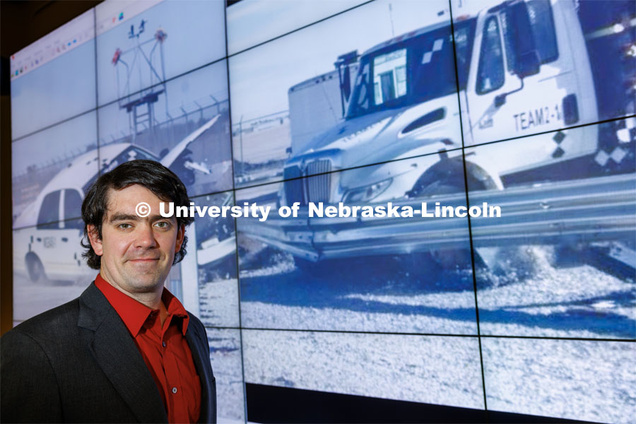 Cody Stolle, Research Assistant Professor, Midwest Roadside Safety Facility, stands in front of a crash video footage from testing done at the UNL Midwest Roadside Safety Facility. Cody Stolle lab in Whittier. July 27, 2023.  Photo by Craig Chandler / University Communication.