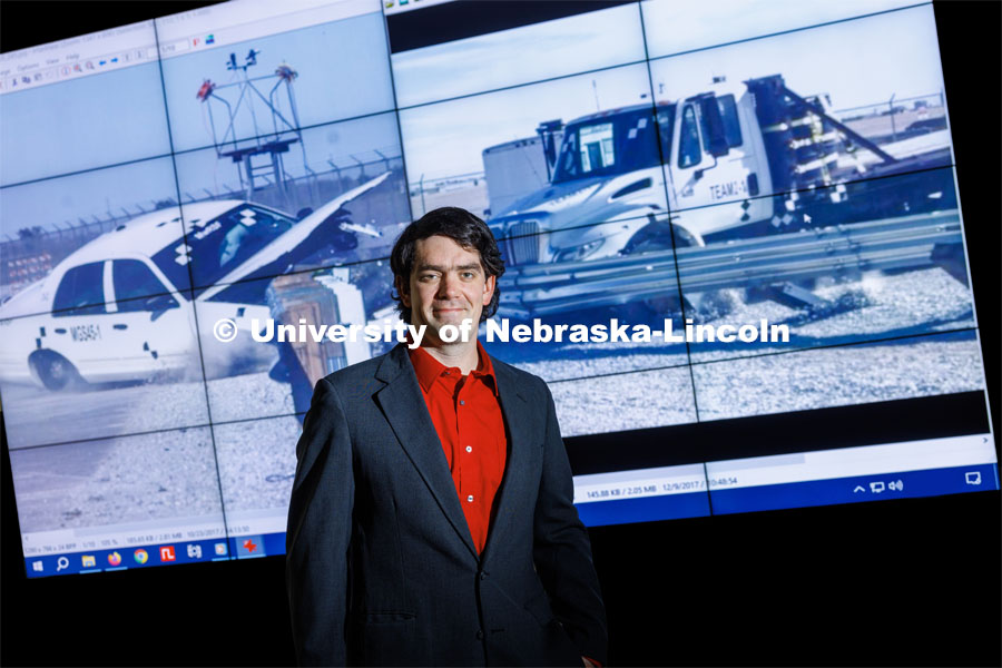 Cody Stolle, Research Assistant Professor Midwest Roadside Safety Facility, stands in front of a video screen showing the results of a barrier crash test. Cody Stolle lab in Whittier. July 27, 2023. Photo by Craig Chandler / University Communication.