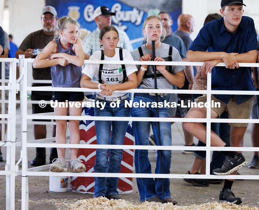 Elise Derickson of Cortland, center, and her friends watch the senior division beef showmanship competition. 4H/FFA Beef Show at the Gage County Fair and Expo in Beatrice. July 28, 2023. Photo by Craig Chandler / University Communication.