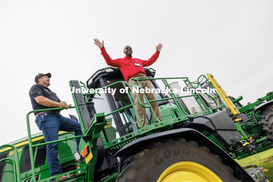 Chancellor Rodney Bennett talks to the tour group from atop a John Deere sprayer that uses cameras and computers to only spray the weeds. At left is Quentin Cooksley, Director of Commercial and Application Business at AKRS Equipment and UNL alumni. The sprayer was being demonstrated at the South Central Ag Lab field day for area farmers. IANR Roads Scholar Tour through Nebraska. August 1, 2023. Photo by Craig Chandler / University Communication.