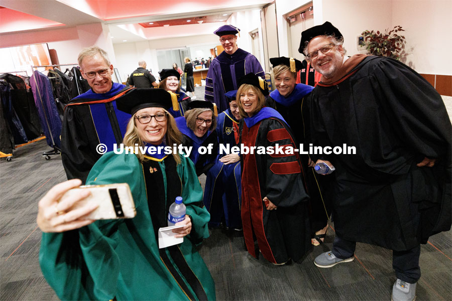 Faculty members decked out in their graduation regalia pose for a selfie before commencement starts. The University of Nebraska–Lincoln is conferring 588 degrees during the combined graduate and undergraduate commencement ceremony at Pinnacle Bank Arena. August 12, 2023. Photo by Craig Chandler/ University Communication.