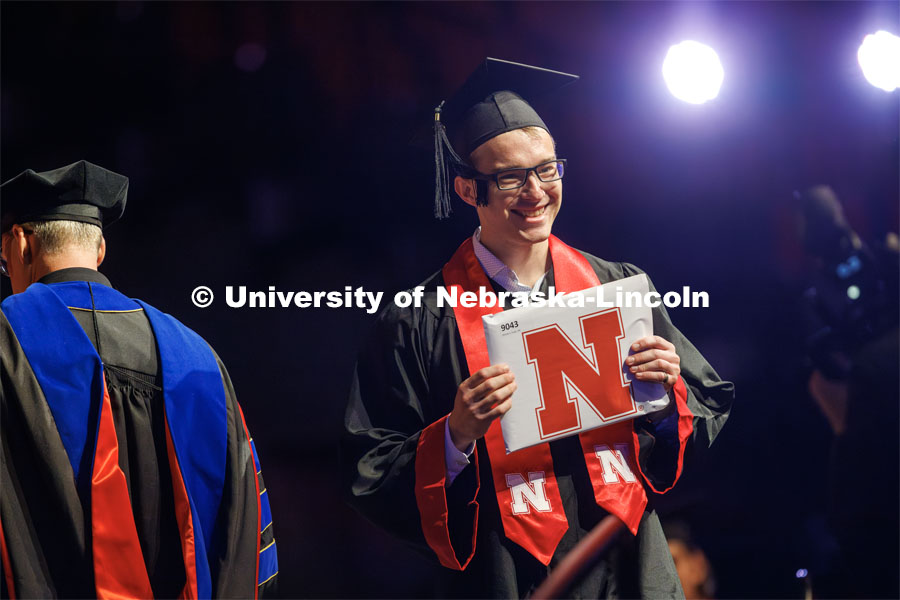 Michael Young gestures to family and friends after receiving his arts and sciences degree. The University of Nebraska–Lincoln is conferring 588 degrees during the combined graduate and undergraduate commencement ceremony at Pinnacle Bank Arena. August 12, 2023. Photo by Craig Chandler/ University Communication.