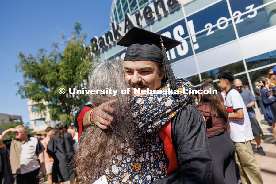 Killian Francis O’Shea-Creal is hugged by family and friends following the ceremony. The University of Nebraska–Lincoln is conferring 588 degrees during the combined graduate and undergraduate commencement ceremony at Pinnacle Bank Arena. August 12, 2023. Photo by Craig Chandler/ University Communication.