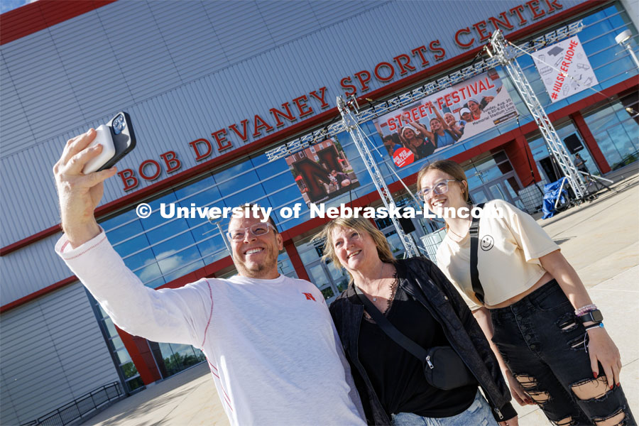 Marissa Brewer of Omaha, right, poses for a selfie with her mom and dad, John and Michelle, as they enter Devaney Sports Center to start the move-in process. First day of residence hall move-in. August 14, 2023. Photo by Craig Chandler/ University Communication.