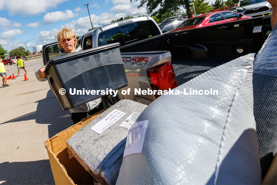 The Student Move-In Team help unload boxes from a truck. First day of residence hall move-in. August 14, 2023. Photo by Craig Chandler/ University Communication.