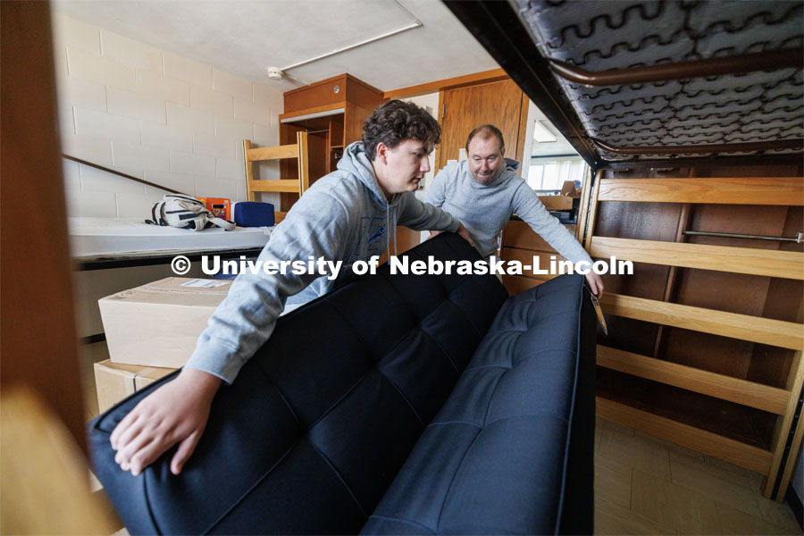 Nick Hauberg and his dad, Kyle, wiggle a futon into place under Nick’s Abel Residence Hall bed. Nick is from Rochester, Michigan, and his dad is a Husker alumnus. Nick is majoring in advertising and public relations. First day of residence hall move-in. August 14, 2023. Photo by Craig Chandler/ University Communication.