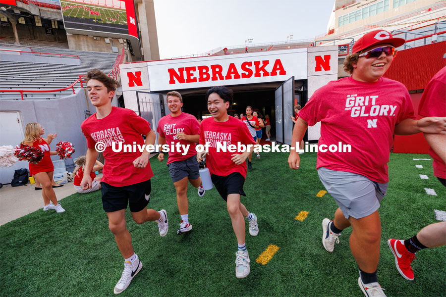 Students charge out of the gates at the Tunnel Walk. Tunnel Walk in Memorial Stadium. August 18, 2023. Photo by Craig Chandler / University Communication.