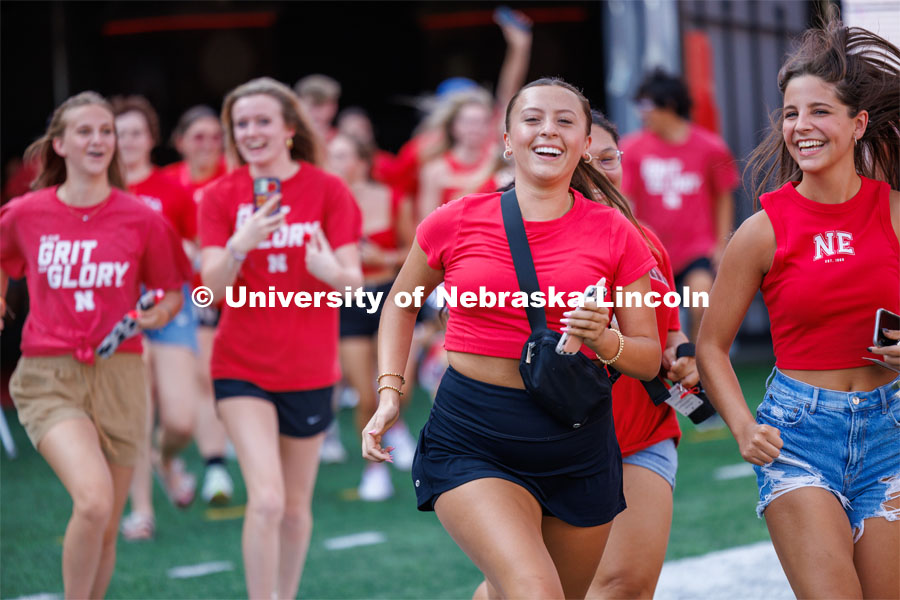 Students charge across the field at the Tunnel Walk. Tunnel Walk in Memorial Stadium. August 18, 2023. Photo by Craig Chandler / University Communication.