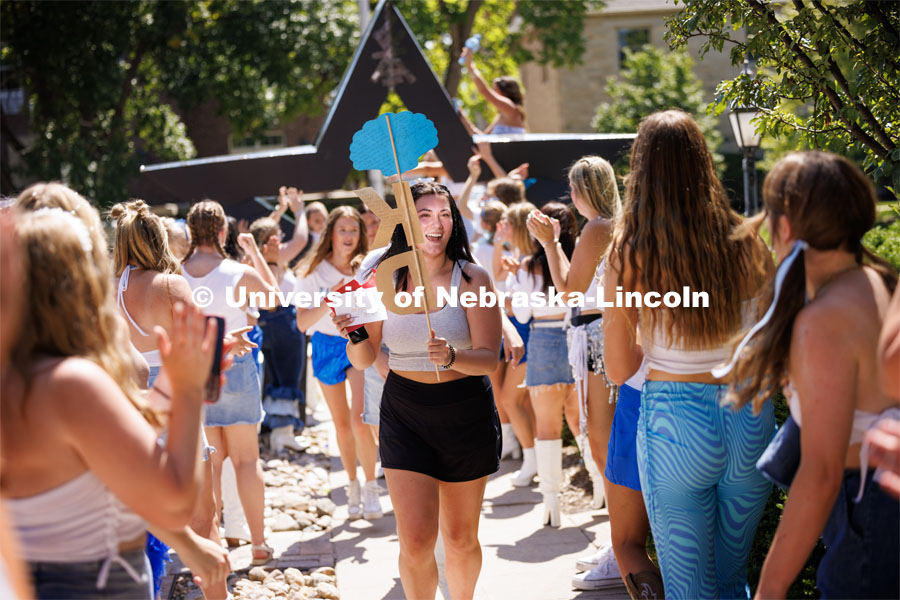 Ava Koziel runs into the Kappa Delta sorority after receiving her bid Saturday afternoon. Sorority Bid Day in the Cather Dining Complex and on the Vine Street Fields. August 19, 2023. Photo by Craig Chandler / University Communication.