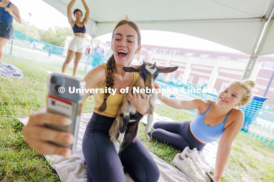 Lillian Brown, a freshman from Dallas, does a selfie with Jasmine the goat kid as Elli Hughes, a freshman from Pierre, South Dakota, reaches in for a pet. Wellness Fest in front of the Nebraska Union and on the green space. August 19, 2023. Photo by Craig Chandler / University Communication.