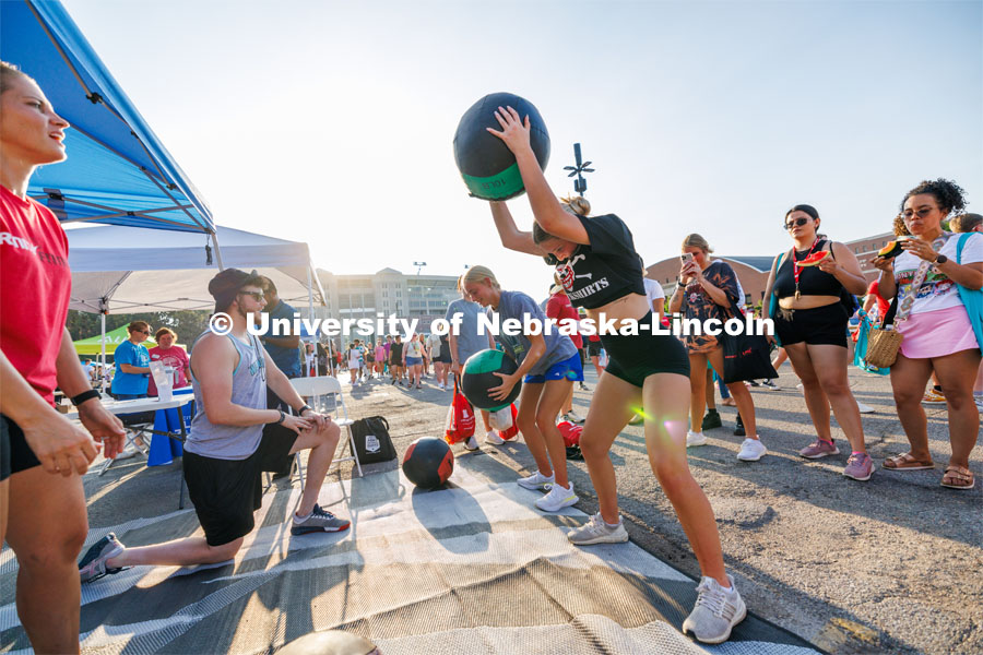 Students slam exercise balls into the ground at the Big Red Welcome Street Fest on the Memorial Stadium loop. Hundreds of clubs and organizations give away stuff to students. August 20, 2023. Photo by Craig Chandler / University Communication.
