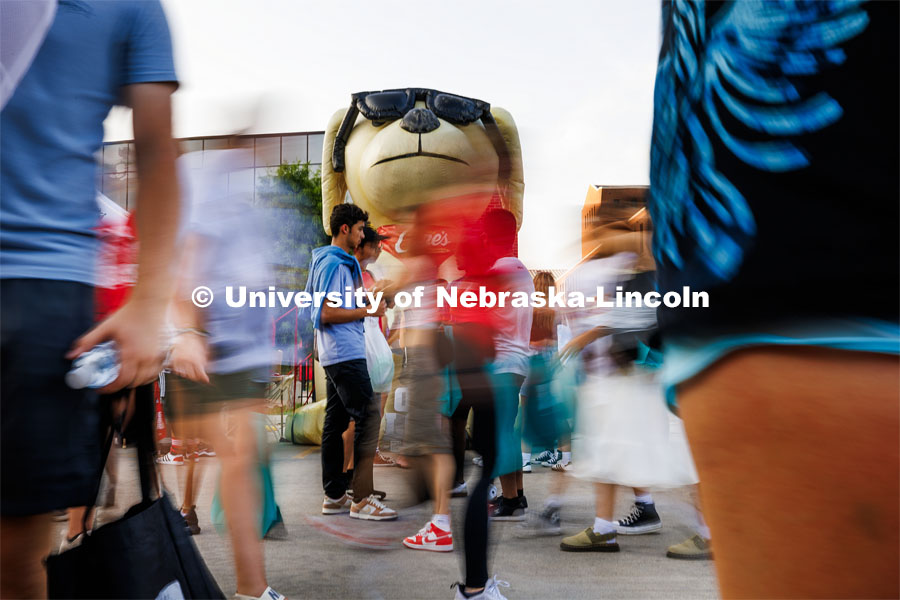 Godzilla Cane watches over the blur of students at the Big Red Welcome Street Fest on the Memorial Stadium loop. Hundreds of clubs and organizations give away stuff to students. August 20, 2023. Photo by Craig Chandler / University Communication.
