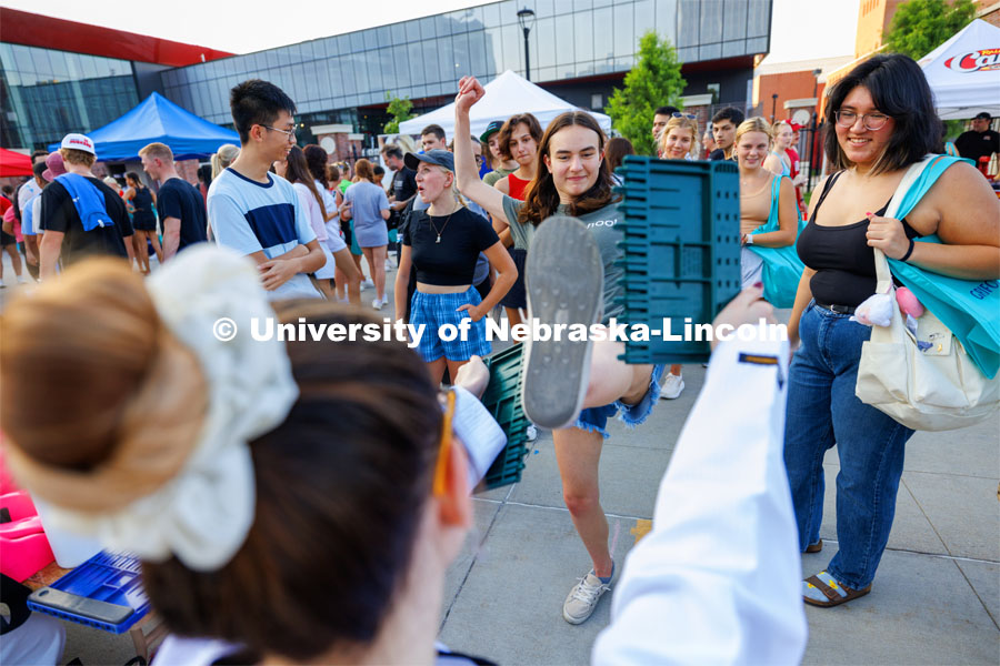 Elena Belashchenko, a sophomore from Lincoln, breaks a board at the Nebraska Taekwondo Club booth. Big Red Welcome Street Fest on the Memorial Stadium loop. Hundreds of clubs and organizations give away stuff to students. August 20, 2023. Photo by Craig Chandler / University Communication.