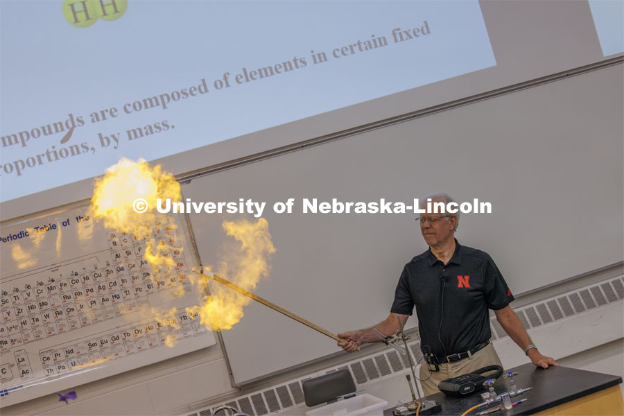 Chemistry 109 began the new school year with a bang. Each Monday lecture demonstrated how atoms can combine into different molecules. Hydrogen and oxygen can make water but can also combine to make an explosive gas. Richard Hartung capped his first lecture with a bang as he exploded a balloon filled with a H2O2 gas and lit it using a candle taped to along stick. First day of classes for fall semester. August 21, 2023. Photo by Craig Chandler / University Communication.