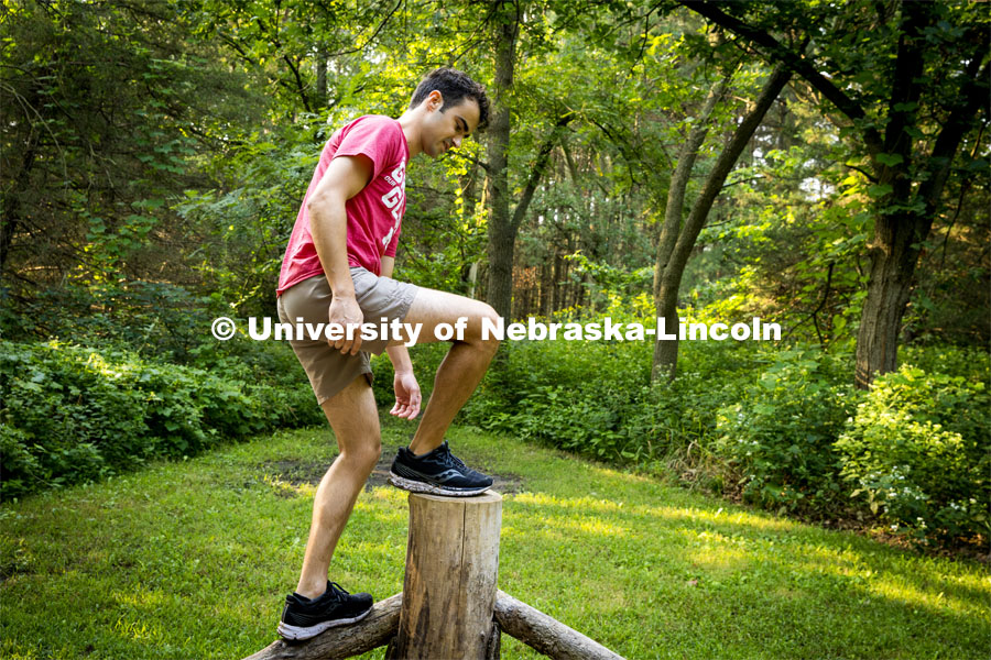 Matthew Strasburger steps on a post at the obstacle course at Prairie Pines. About Lincoln at Prairie Pines. August 29, 2023. Photo by Kristen Labadie / University Communication.
