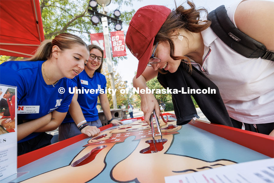 Jenna Wolfe, a senior from Lincoln, removes a charlie horse from the patient in an oversized Operation game under the watchful eyes the Campus Rec injury prevention and care team. Campus Safety Fair in front of Nebraska Union. September 7, 2023. Photo by Craig Chandler / University Communication.