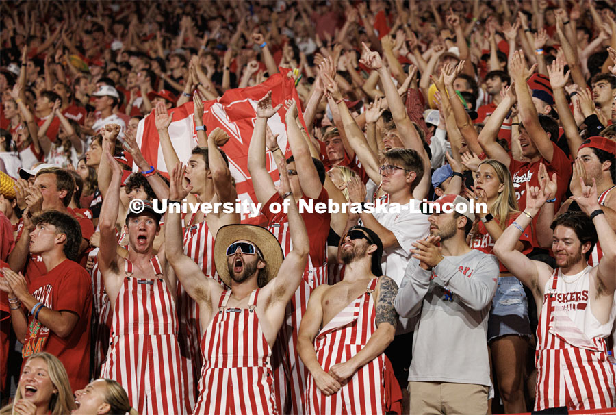 Fans in striped overalls cheer on the Husker football team. Northern Illinois football in Memorial Stadium. September 16, 2023. Photo by Craig Chandler / University Communication.