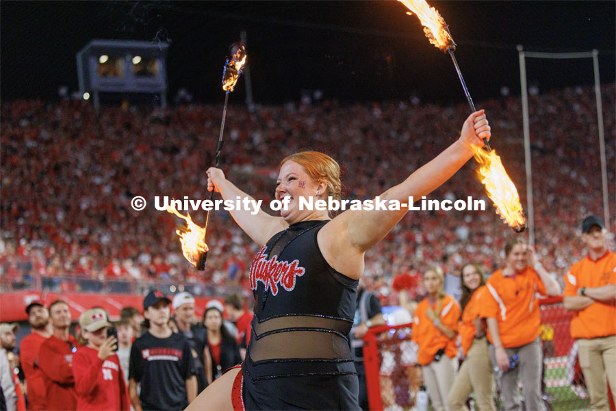 One of the twirlers for the Cornhusker Marching Band twirls flaming batons. Northern Illinois football in Memorial Stadium. September 16, 2023. Photo by Craig Chandler / University Communication.