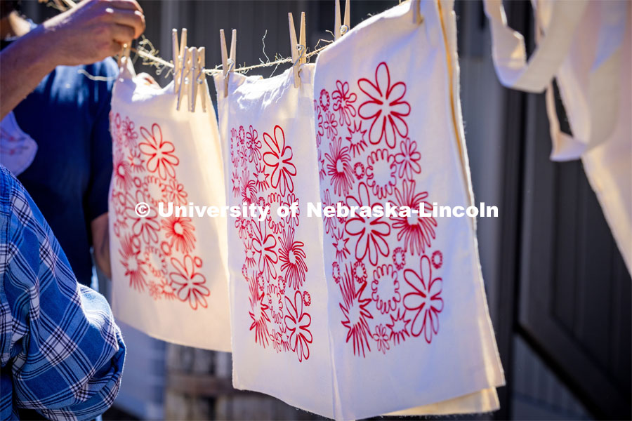 Painted tote bags are clothes pinned to a line to dry at the Lux Street Art Festival. About Lincoln – Lux Street Art Festival. September 24, 2023. Photo by Kristen Labadie / University Communication.