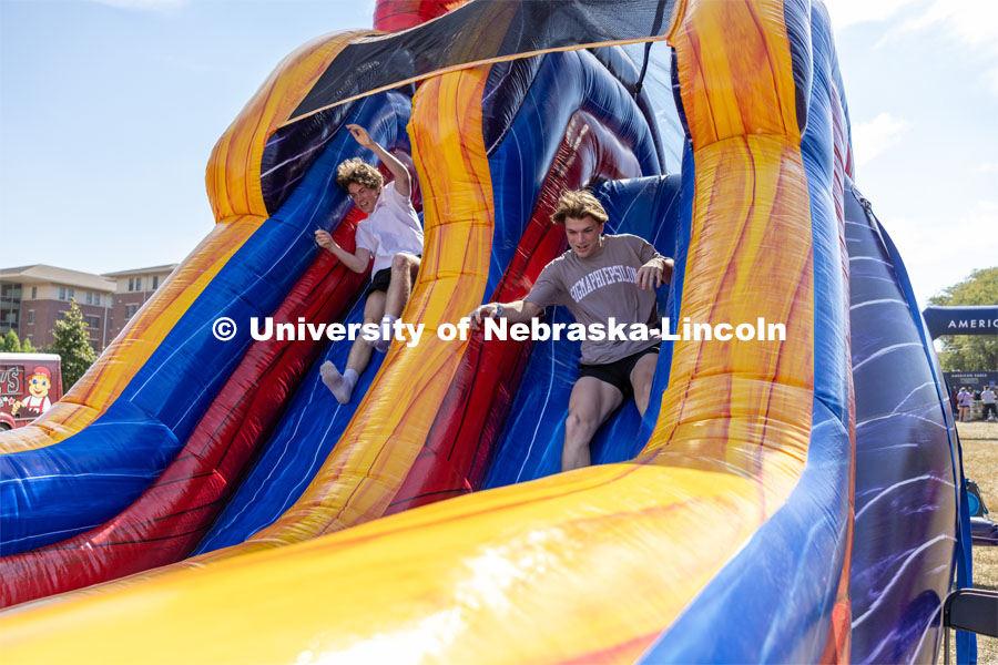 Brady McGerr races with friend Noah Rachwitz through an inflatable obstacle course at Hanging with the Huskers event. September 29, 2023. Photo by Dillon Galloway for University Communications.