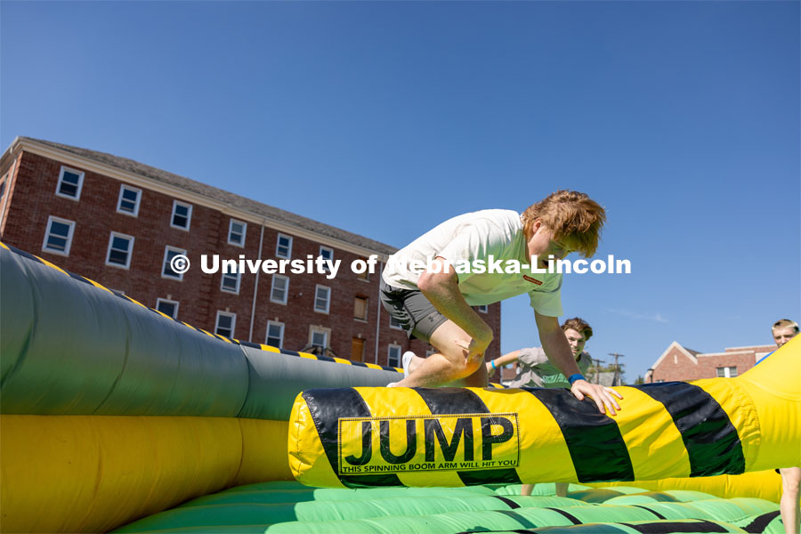 Brady McGerr jumps over the spinning inflatable at Hanging with the Huskers. September 29, 2023. Photo by Dillon Galloway for University Communications.