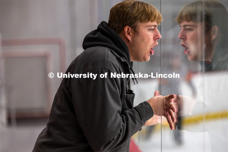 Fan leans against the plexiglass and shouts after hockey player misses goal. Husker Hockey at Breslow Ice Hockey Center. October 7, 2023. Photo by Dillon Galloway for University Communication and Marketing.