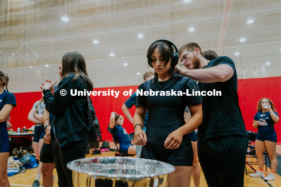 Nedaa Majo, senior, having chalk applied on her back during the Strong Husker Powerlifting meet hosted by UNL Barbell Club in the Coliseum. October 7, 2023. Photo by Jonah Tran / University Communication