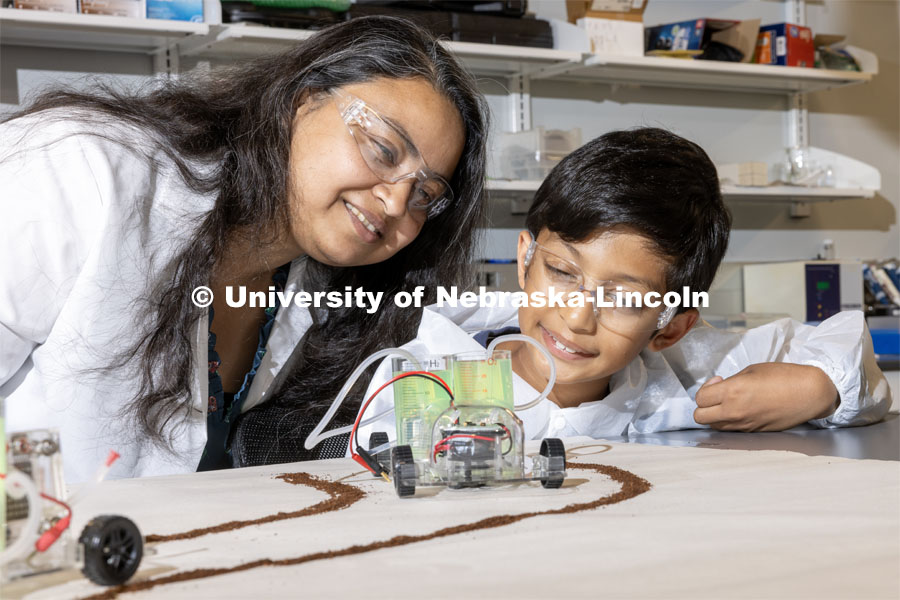 Shudipto Dishari watches Sreyan Saha as he plays with cars powered by green energy using biomaterials. Dishari, associate professor of chemical and biomolecular engineering, recently began work on a three-year, $489,134 grant from the National Science Foundation could revolutionize the way devices produce, transport and store electricity. October 10, 2023. Photo by Craig Chandler / University Communication.