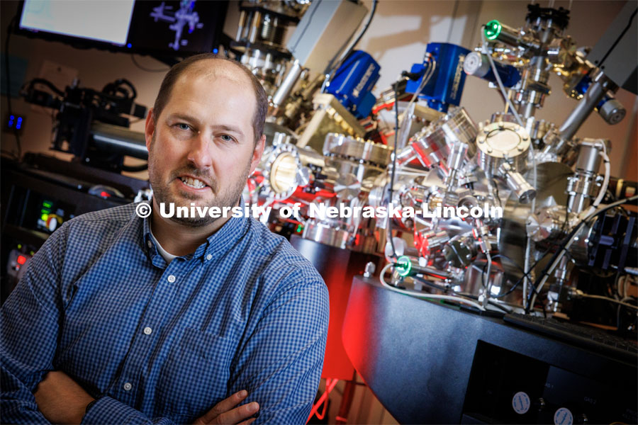 Craig Zuhlke poses with the Leybold ultra-high vacuum laser surface processing and materials analysis system in the Engineering Research Center. Professors Zuhlke and Gogos are co-directors of the Center for Electro-optics and Functionalized Surfaces. October 10, 2023. Photo by Craig Chandler / University Communication.