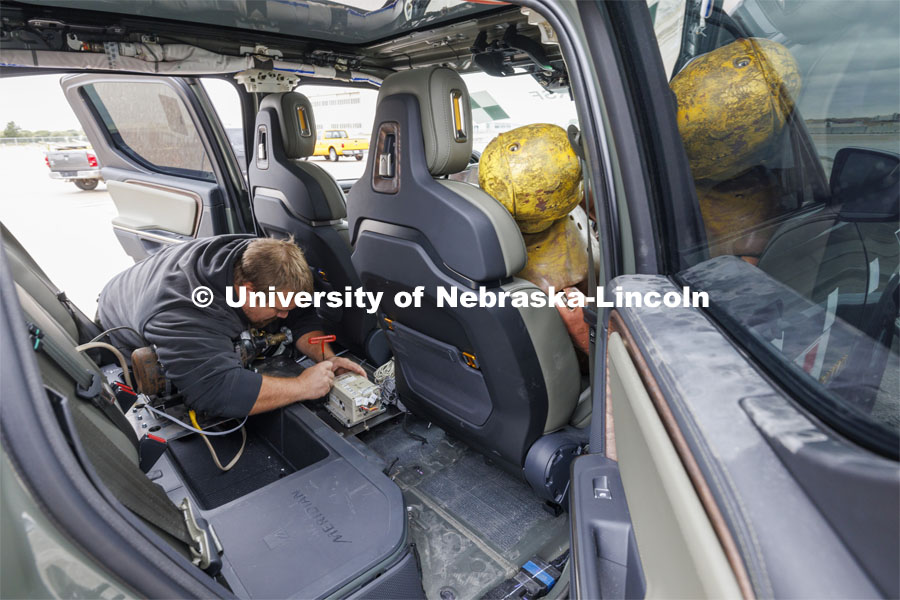 Trevor Donahoo, Engineering Testing Technician, connects testing equipment inside the Rivian R1T cab before the crash test. In research sponsored by the U.S. Army Engineer Research and Development Center, the University of Nebraska-Lincoln’s Midwest Roadside Safety Facility is investigating the safety and military defense questions raised by the burgeoning number of electric vehicles on the nation’s roadways. A crash test performed on a guardrail on October 12, 2023, highlighted the concern. At 60 mph, the 7,000-plus-pound, 2022 Rivian R1T truck tore through a commonly used guardrail system with little reduction in speed. October 12, 2023. Photo by Craig Chandler / University Communication and Marketing.