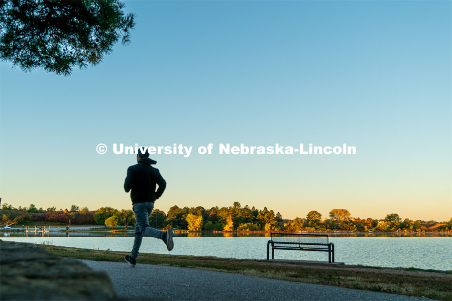 A jogger runs the walking path at Holmes Lake. About Lincoln at Holmes Lake. October 20, 2023. Photo by Matthew Strasburger / University Communication.