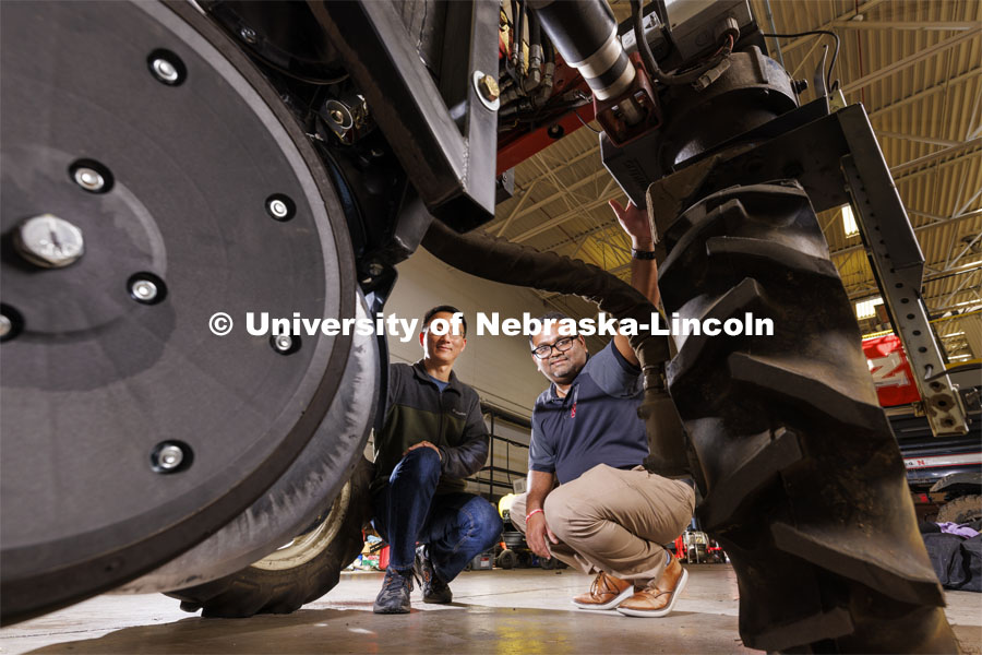 BSE Professors Yufeng Ge (left) and Santosh Pitla inspect the Flexible Robot, or Flex-Ro, which is outfitted with sensors that collect data and help the vehicle avoid obstacles. A planter for Mars would be much smaller so it can be transported easier and also because the “fields” would probably be in enclosed spaces. Photo illustration for Space 2, the Nebraska Grand Challenge led by professors in Biological Systems Engineering to grow crops on Mars. October 20, 2023. Photo by Craig Chandler / University Communication.