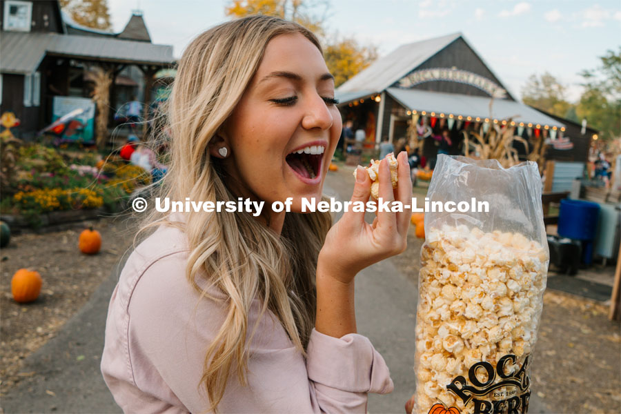 Husker Cheerleader Peyton Prussa enjoys a bag of popcorn at Roca Berry Farm. About Lincoln at Roca Berry Farm. October 22, 2023. Photo by Matthew Strasburger / University Communication.