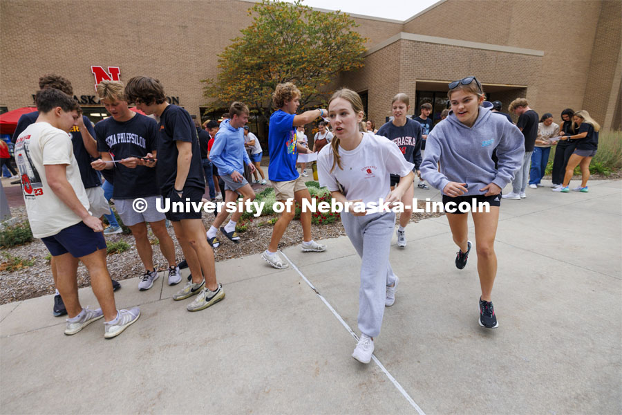 Outside of the Nebraska East Union, teams open their first clue envelope and run in multiple directions to begin the race. Each team is sent in a different order to each of 10 locations where they collect a clue to their next destination. Homecoming Traditions Race. Registered teams compete in a race to find 10 landmarks in an hour on UNL’s East Campus. October 24, 2023. Photo by Craig Chandler / University Communication.