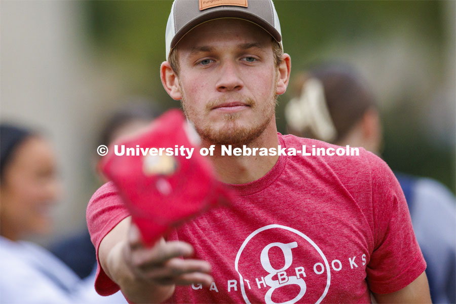 Bryce Wemhoff, who was competing for the Newman Center, lets a bag fly during Homecoming Cornhole Tournament in the greenspace by the Nebraska Union. October 25, 2023. Photo by Craig Chandler / University Communication.