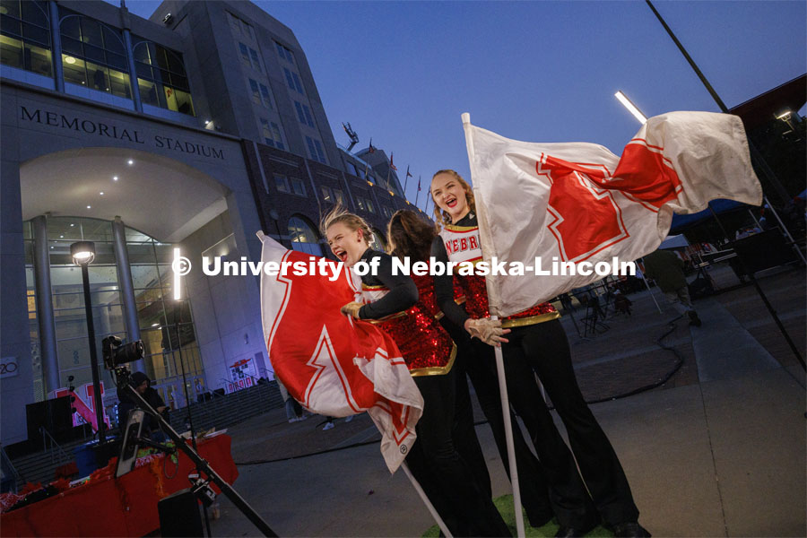 Cornhusker Marching Band color guard members Alyssa Johnson and Cheyanne Pace cheer as they pose in a 360 degree photo booth. Homecoming parade and Cornstock. October 27, 2023. Photo by Craig Chandler / University Communication.