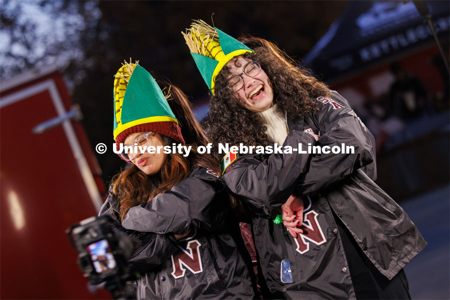 Monica Samaniego, left, and Solenne Halman Gonzalez wear corn hats and their Lambda Theta Nu sorority jackets as they pose in a 360 degree photo booth. Homecoming parade and Cornstock. October 27, 2023. Photo by Craig Chandler / University Communication.