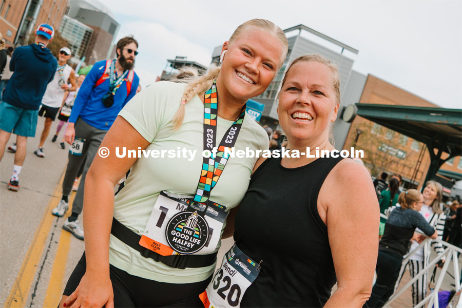 Runners pose for a picture with their medals. The Good Life Halfsy half marathon runs through the streets of Lincoln and end downtown in the Haymarket. About Lincoln at the Good Life Halfsy. November 5, 2023. Photo by Matthew Strasburger / University Communication.