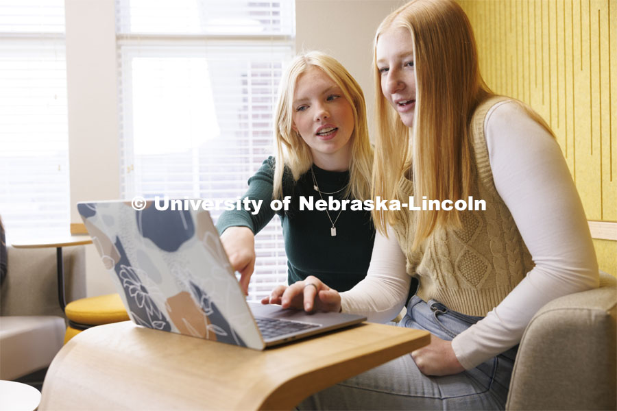 Madalyn Schoneman, center, and Alexis Tenorio look over work on the laptop in the Knoll Residential Center lounge. A University of Nebraska–Lincoln team’s proposed renovation of a little-used TV lounge in the Robert E. Knoll Residential Center features multiple study spaces designed to allow for collaboration between students won the 2019 Big Ten Academic Alliance Student Design Challenge. Following pandemic delays, the furniture has been delivered. The annual contest, supported by the Herman Miller furniture company, allows students to develop and pitch a renovation of an existing campus space. November 17, 2023. Photo by Craig Chandler / University Communication and Marketing.
