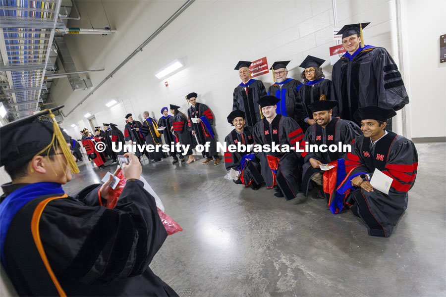 Physics and Astronomy PhD candidates pose with their advising faculty before the ceremony. Graduate Commencement at Pinnacle Bank Arena. December 15, 2023. Photo by Craig Chandler / University Communication and Marketing.