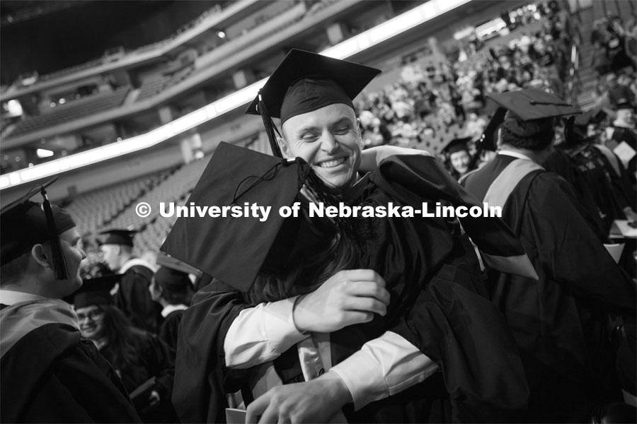 Nicholas Prusia hugs Meagan Peterson at the end of Regent Tim Clare’s greeting where he asked graduates to show their appreciation for their friends and fellow graduates. Graduate Commencement at Pinnacle Bank Arena. December 15, 2023. Photo by Craig Chandler / University Communication and Marketing.