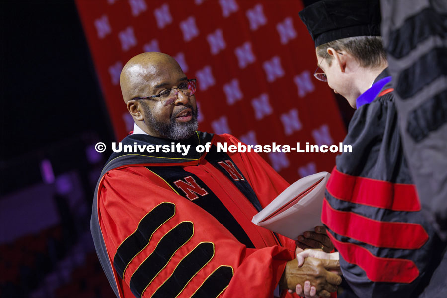 Chancellor Rodney D. Bennett awards a diploma to a PhD graduate. Graduate Commencement at Pinnacle Bank Arena. December 15, 2023. Photo by Craig Chandler / University Communication and Marketing.
