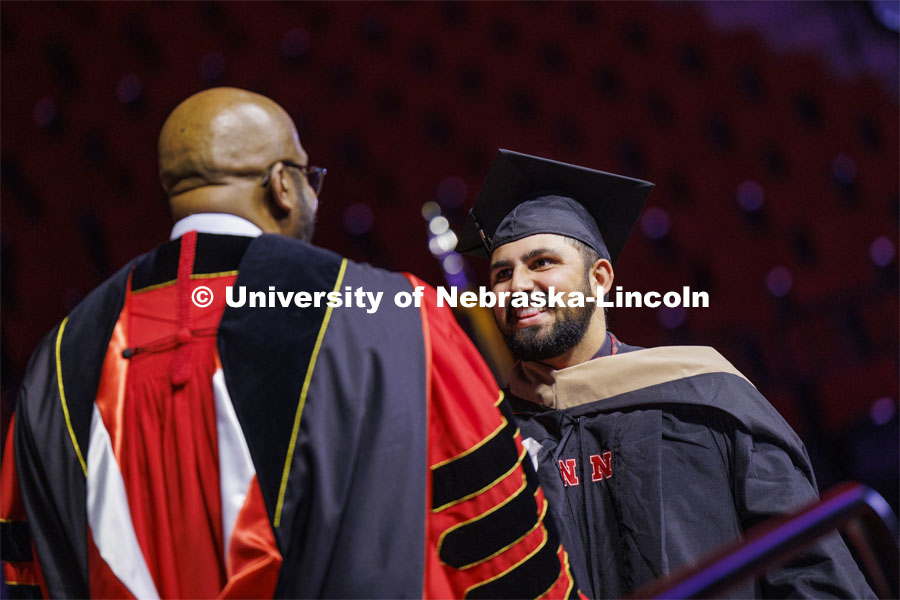 Alex Fernando shakes hands with Chancellor Rodney Bennett after being given his MBA diploma. Graduate Commencement at Pinnacle Bank Arena. December 15, 2023. Photo by Craig Chandler / University Communication and Marketing.