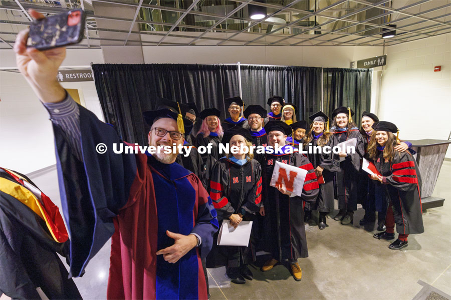 Doctor of Educations graduates and their advising professors pose for a selfie following the ceremony. Graduate Commencement at Pinnacle Bank Arena. December 15, 2023. Photo by Craig Chandler / University Communication and Marketing.